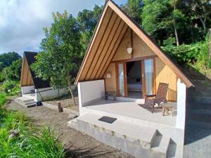 a small house with a porch and a patio at Pondok Kenali Glamping in Kubupenlokan