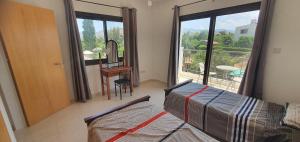 a bedroom with a bed and a desk and a window at Lavin - 3Bedroom Maisonette in Argaka