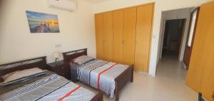 a room with two beds and a closet at Lavin - 3Bedroom Maisonette in Argaka