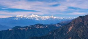 a mountain range with snow capped mountains in the distance at Titli home stay in Lingtām