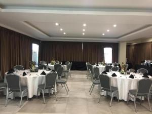 une salle de banquet avec des tables et des chaises blanches dans l'établissement Travelite Hotel Legarda, à Baguio