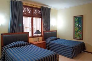 a hotel room with two beds and a window at Resort Prima Sangkanhurip in Panawuan
