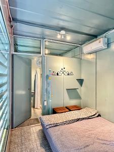 a small bedroom with a bed and a sliding glass door at Nunou Cafe in Ban Than Lao