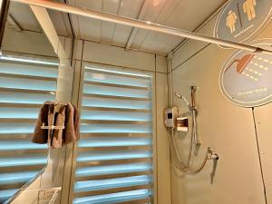 a shower in a bathroom with blue blinds at Nunou Cafe in Ban Than Lao +85 photos