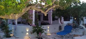 a patio with two chairs and a table with lights at Ο Κήπος The Garden in Sitia