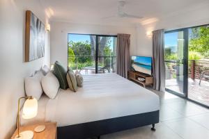 a bedroom with a large bed and a balcony at Compass Point on Hamilton Island by HIHA in Hamilton Island +32 photos