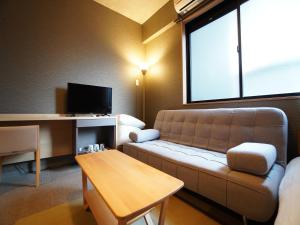 un soggiorno con un divano e un tavolo di MUSUBI HOTEL Kyoto Shijo-Omiya a Kyoto