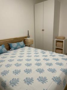 a bedroom with a bed with a blue and white blanket at Falce di luna in Tortoreto Lido