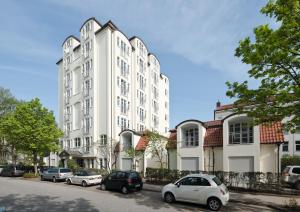 un edificio blanco con coches estacionados frente a él en SMARTments business Hamburg Aussenalster, en Hamburgo