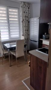 a kitchen with a table and chairs and a refrigerator at ЕкоПойнт in Chernomorets