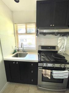 a kitchen with a stove and a sink at Cozy Guest Rooms Near UBC, Downtown and Beaches in Vancouver