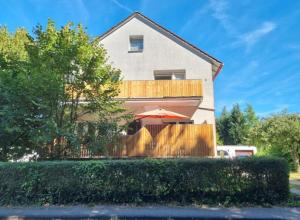 een huis met een hek en een paraplu bij Tetzlaff - Ferienwohnungen am Deister, FeWo 1 mit Balkon in Bad Münder am Deister