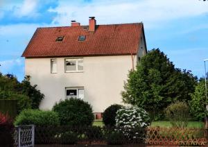 een wit huis met een rood dak bij Tetzlaff - Ferienwohnungen am Deister, FeWo 1 mit Balkon in Bad Münder am Deister