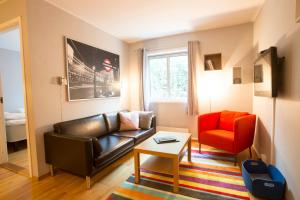 a living room with a leather couch and a red chair at Frogner House - Lagårdsveien 13 in Stavanger