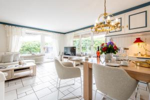 a kitchen with a table and chairs and a living room at Haus Südkap in Hörnum