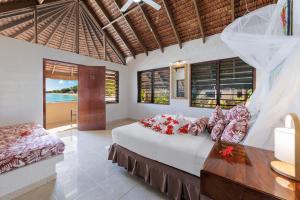 una camera da letto con un letto, un tavolo e finestre di Breakas Beach Resort a Port Vila