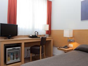 a bedroom with a television and a bed at Hotel Sagrada Familia in Barcelona