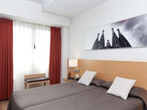 1 dormitorio con 1 cama grande y cortinas rojas en Hotel Sagrada Familia, en Barcelona