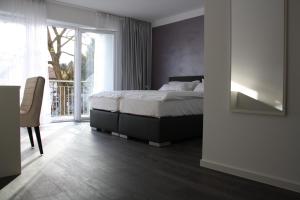 a bedroom with a bed and a desk and a window at Victoria Living in Jockgrim