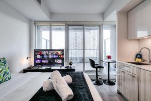 una camera da letto con un letto con asciugamani sopra di RivetStays - The Jarvis a Toronto