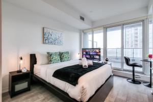a bedroom with a large bed and a window at RivetStays - The Jarvis in Toronto