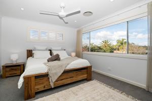 a bedroom with a bed and a large window at Lakeshore Serenity @ Warners Bay in Warners Bay +28 photos