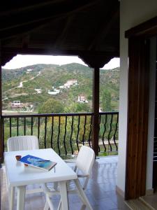 a white table and two white chairs on a balcony at Villa Anna Maria in Agia Paraskevi