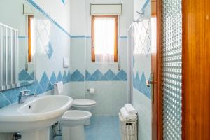 Il Rosmarino في باري ساردو: حمام ازرق وابيض مع مغسلة ومرحاض
