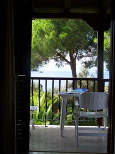 a table and chairs on a porch with a view of the ocean at Villa Anna Maria in Agia Paraskevi