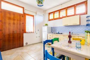 Il Rosmarino في باري ساردو: مطبخ مع طاولة مع زجاجة من النبيذ