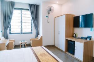 a hotel room with a bed and a table and chairs at Bảo Ngọc Hotel in Uông Bí