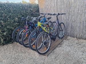 a row of bikes parked next to a wall at Camping les dunes Torreilles Plages - Bungalow M027 chez D&D in Torreilles