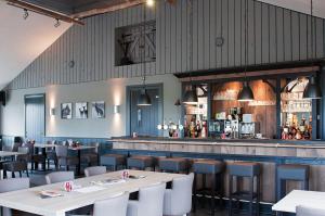 a restaurant with tables and chairs and a bar at Vakantiepark Camping de Peelpoort in Asten-Heusden