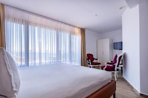 A bed or beds in a room at Mangana Konak Hotel