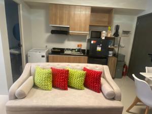 a couch with four colorful pillows on it in a kitchen at Kral Suite in Las Piñas in Manila