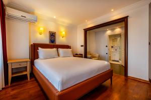 A bed or beds in a room at Mangana Konak Hotel