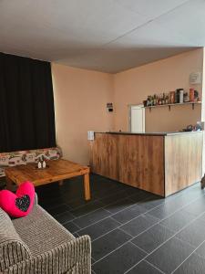 Una sala de estar con un mostrador, una mesa y un refrigerador. en Guest House Petrovi, en Ravda