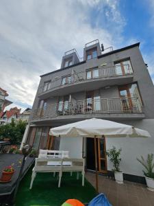 un edificio con una sombrilla delante de él en Guest House Petrovi, en Ravda