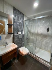 a bathroom with a shower and a sink and a tub at Green Palmiye Hotel in Avcılar +21 photos