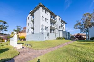 Krait Court, 6-6 Krait Close في خليج نيلسون: مبنى أبيض كبير على حقل عشبي