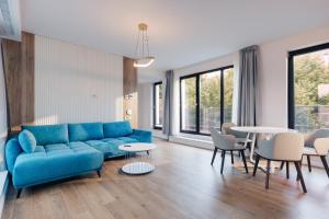 a living room with a blue couch and a table at Syndicate Lodging Aparthotel in Cluj-Napoca