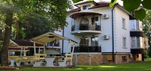 una casa bianca con un balcone sul lato di Anastasija Sobe AS a Vrnjačka Banja