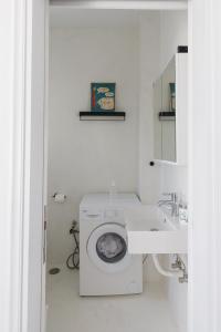 a white bathroom with a toilet and a sink at Harbour View Holiday Home in Ermoupoli +64 photos