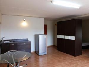 ノンタブリーにあるAsia Don Mueang Bangkok Condominiumのキッチン(テーブル、冷蔵庫付)が備わります。