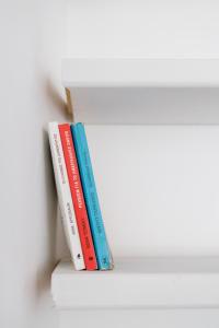 three books sitting on top of a shelf at Harbour View Holiday Home in Ermoupoli