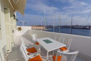 a table and chairs on a balcony with a view of the water at Harbour View Holiday Home in Ermoupoli