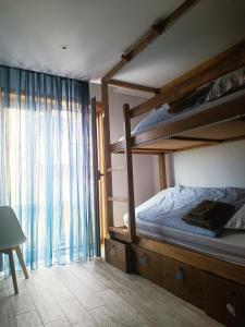ein Schlafzimmer mit zwei Etagenbetten und einem Fenster in der Unterkunft Cachinnans Hostel & Apartments in Vila do Conde + 10 Fotos