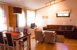 uma sala de estar com uma mesa e um sofá em Break Sokos Hotel Vuokatti Apartments em Vuokatti
