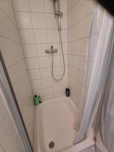 a bathroom with a shower with a white tub at SUITE Top View & City Alex 4 rooms 2 bathrooms 1 kitchen in Berlin +16 photos