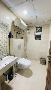 un baño con inodoro y lavabo en Vickysoho, en Zirakpur
